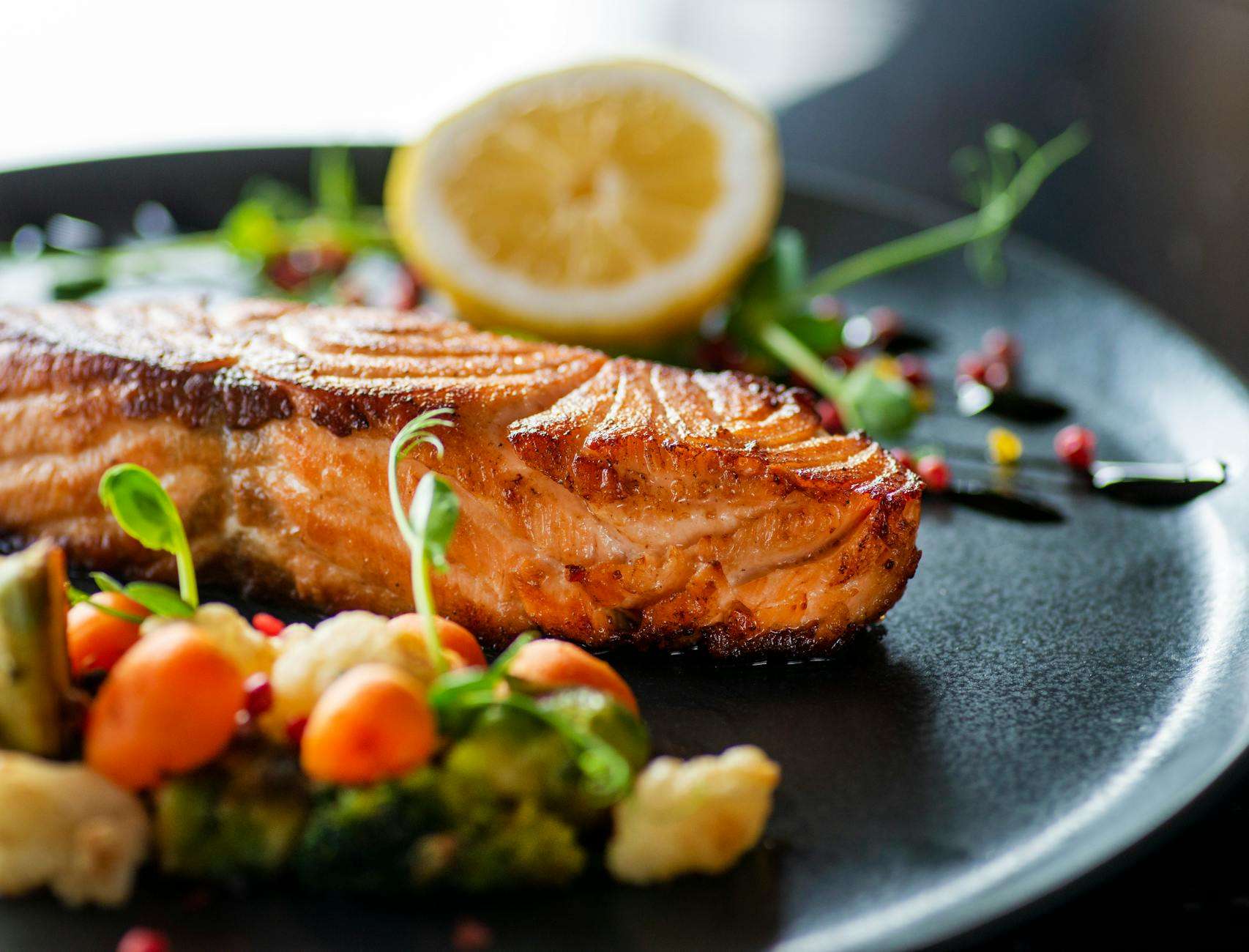 close up shot of delicious grilled salmon on black plate