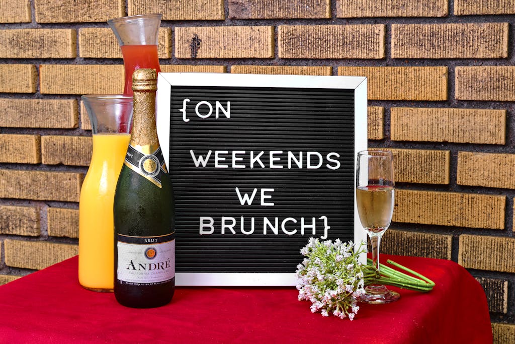 Stylish brunch setting with champagne, juice, and a letter board message.